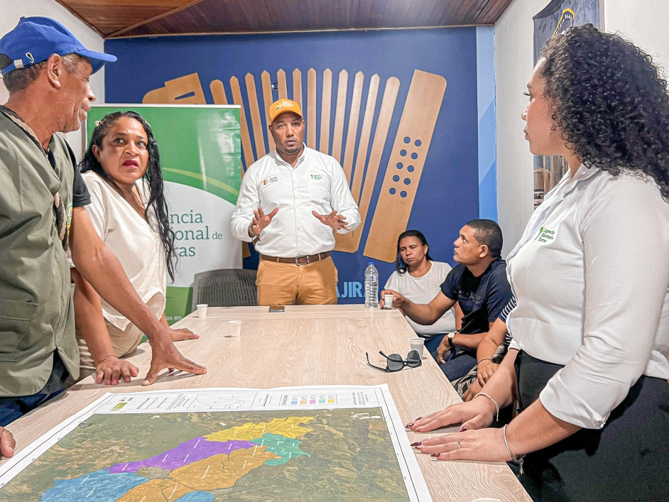 un-grupo-de-personas-de-pie-alrededor-de-una-mesa-con-un-mapa