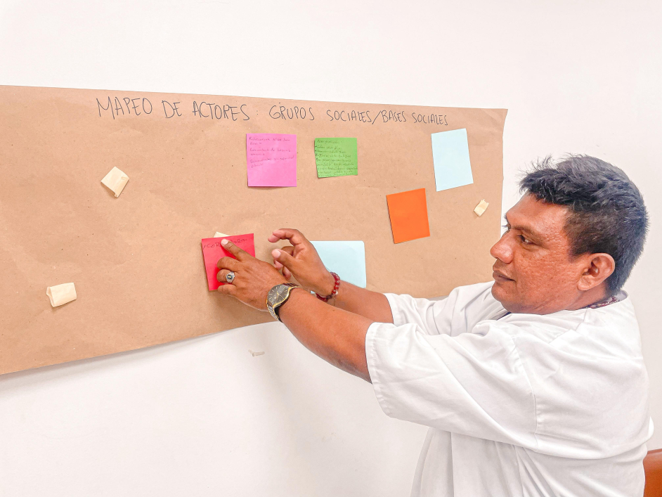 un-hombre-con-una-camisa-blanca-que-apunta-a-una-tabla-de-notas