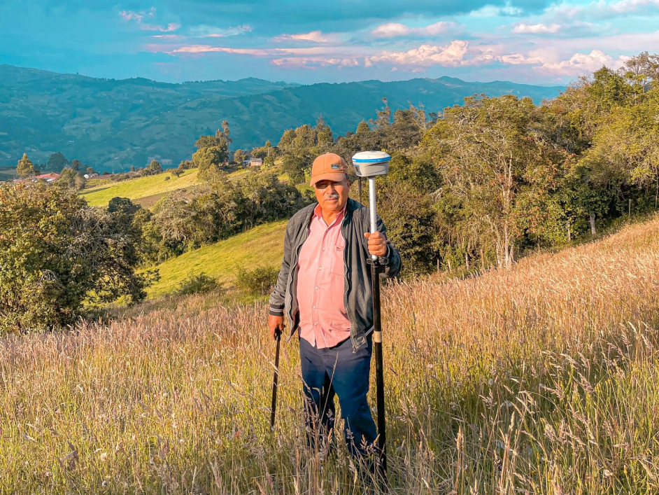 un-hombre-de-pie-en-un-campo-sosteniendo-un-poste