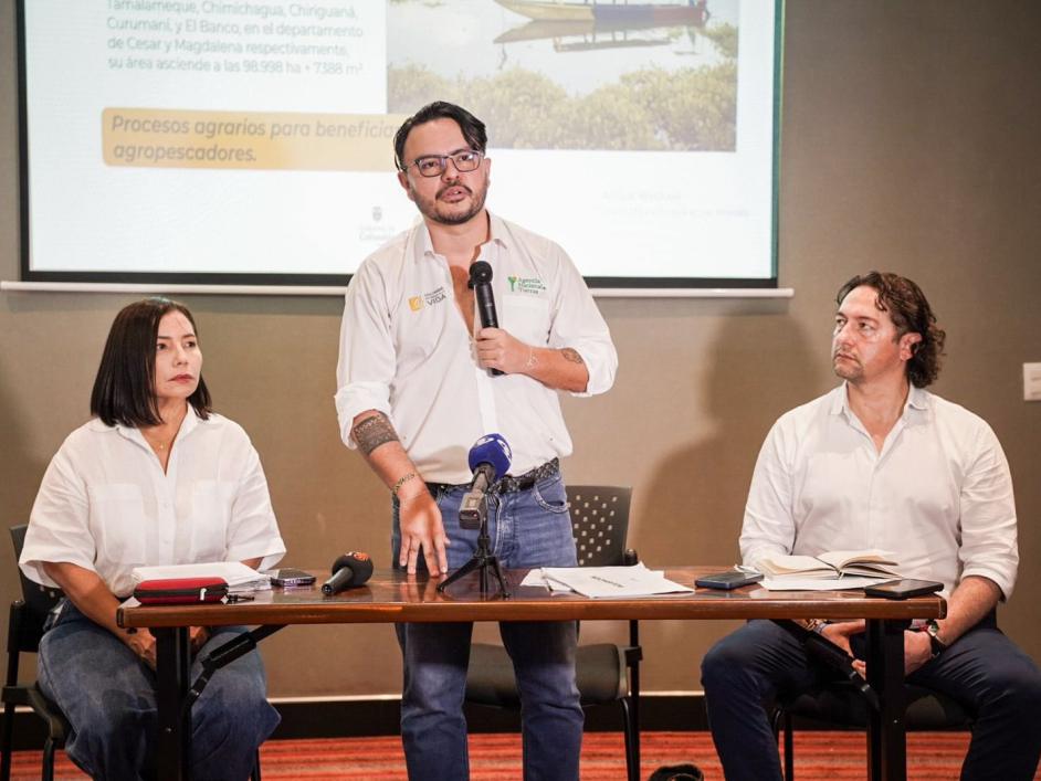 tres-personas-sentadas-en-una-mesa-con-una-pantalla-de-presentacion