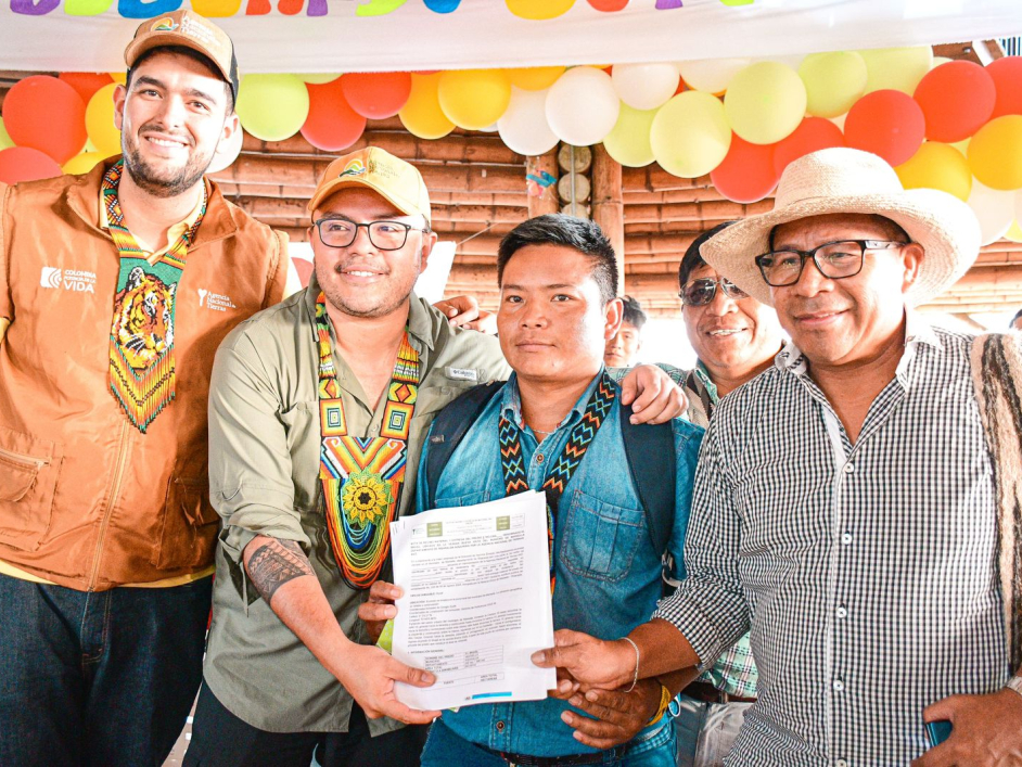 director-ant-junto-a-un-grupo-de-personas-paradas-sosteniendo-documento-de-tierras-ant