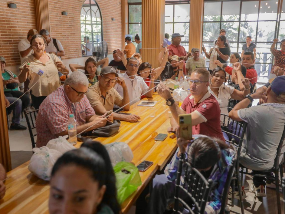 gente-sentada-en-una-mesa-con-un-hombre-sosteniendo-una-cuerda