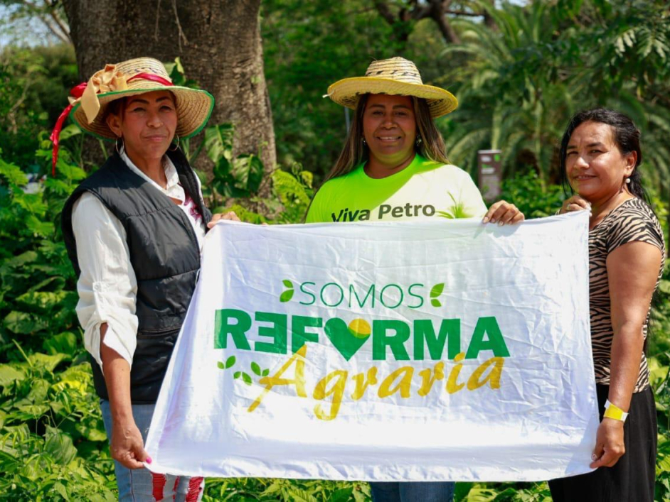 tres-mujeres-sosteniendo-una-pancarta-que-dice-reforma-agraria