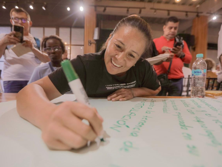 una-mujer-sonre-mientras-escribe-en-una-pizarra-blanca